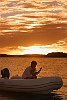 The Kingdom Of Tonga in the South Pacfic <br>Too noisy on the boat, so relaxing with a book and a glass of wine in the tender while the sun sets over the islands.