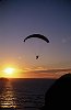 Paragliding in to the sun set over the water.